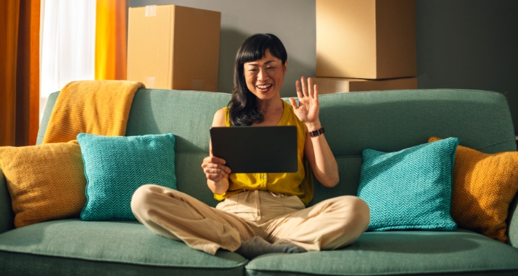 Woman holding tablet, smiling and waving
