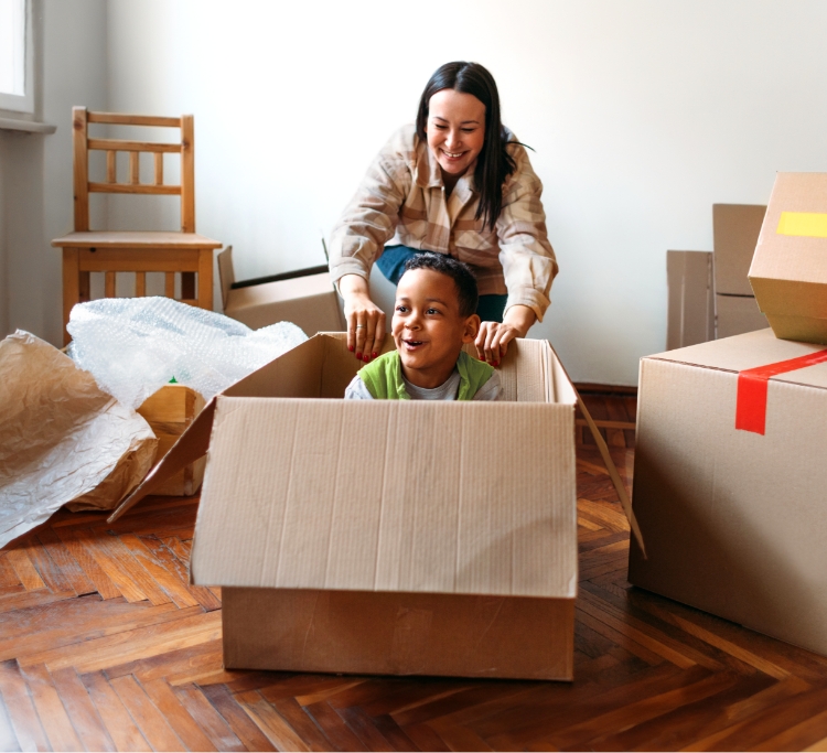 Smiling mom with son sitting in a moving box
